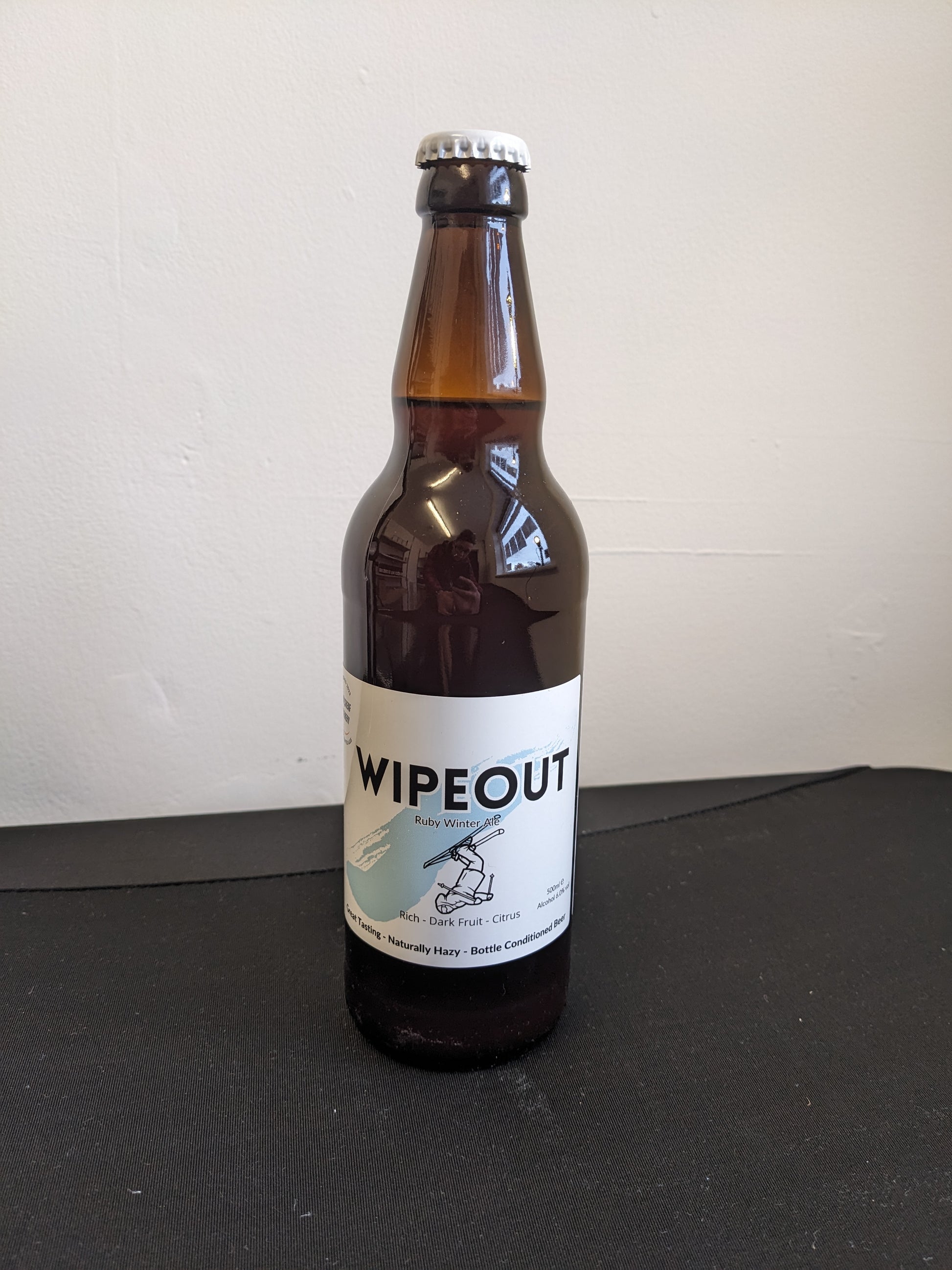Brown beer bottle with cap. Wipeout Ruby Ale. Great Tasting Naturally Hazy Bottle Conditioned Beer