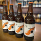 Four bottles of Armageddon golden ale on the shelf with orange caps. Bottle conditioned real ale brewed in Huntingdon UK