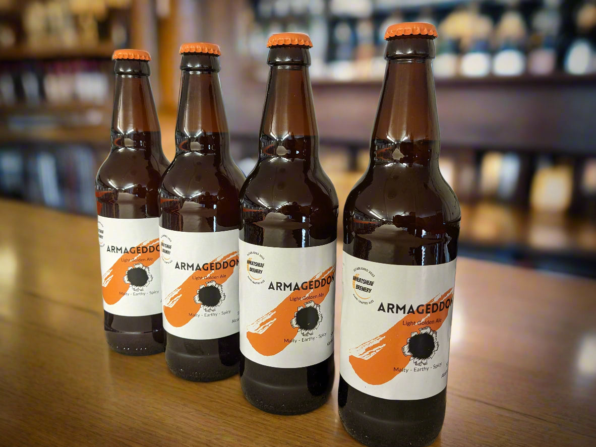 Four bottles of Armageddon golden ale on the shelf with orange caps. Bottle conditioned real ale brewed in Huntingdon UK